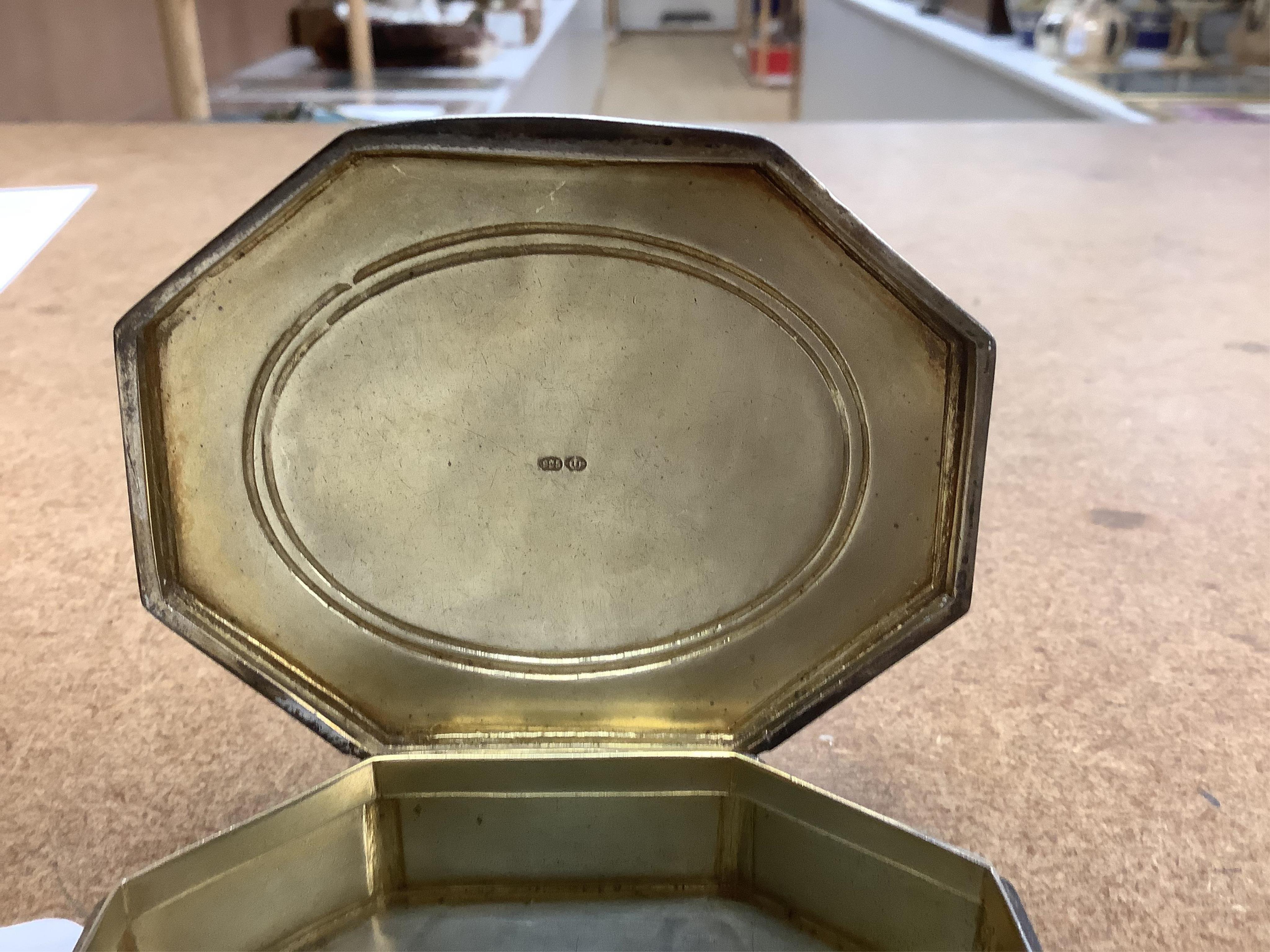 An Edwardian silver and guilloche enamel octagonal box with hinged cover, import marks for Erich Kellerman, London, 1909, decorated with flowers and musical instruments, 77mm.